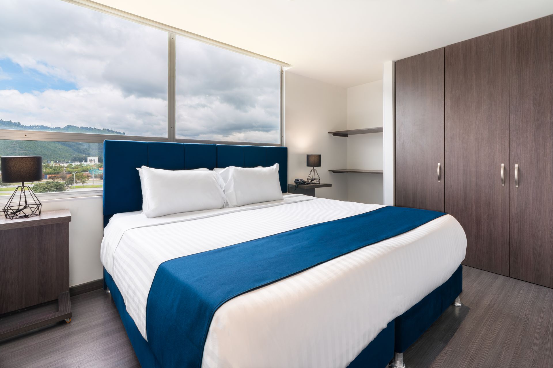 Una habitación de hotel con una cama grande y una ventana grande.