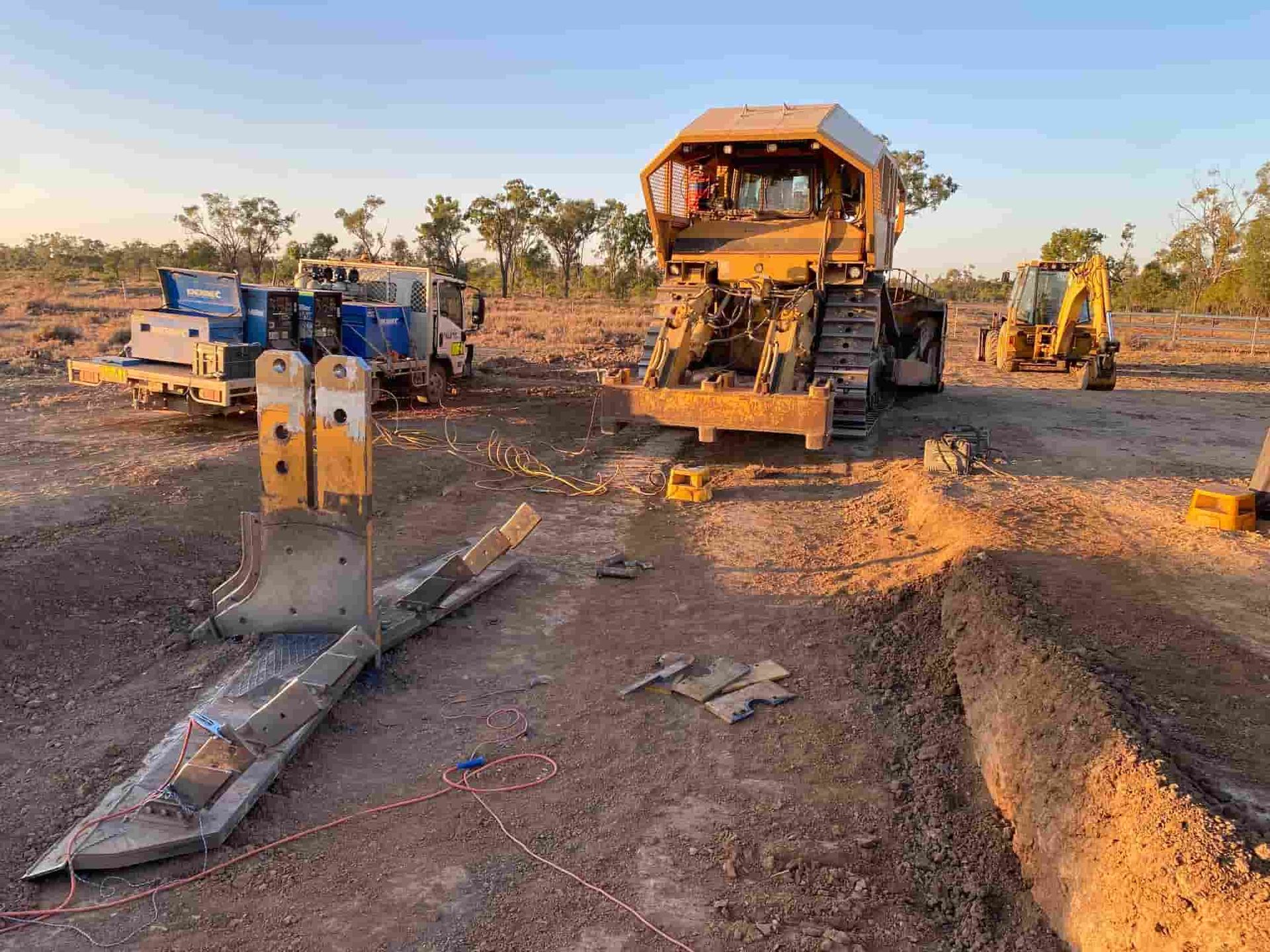 A Group of Bulldozers Are Parked in a Dirt Field — North Queensland Hard Facing (NQHF) In Cloncurry, QLD
