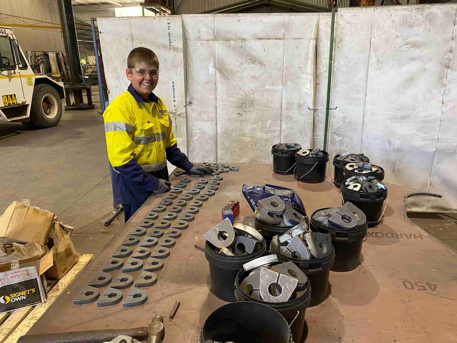 A Man is Standing in Front of a Table — North Queensland Hard Facing (NQHF) In Fredericksfield, QLD