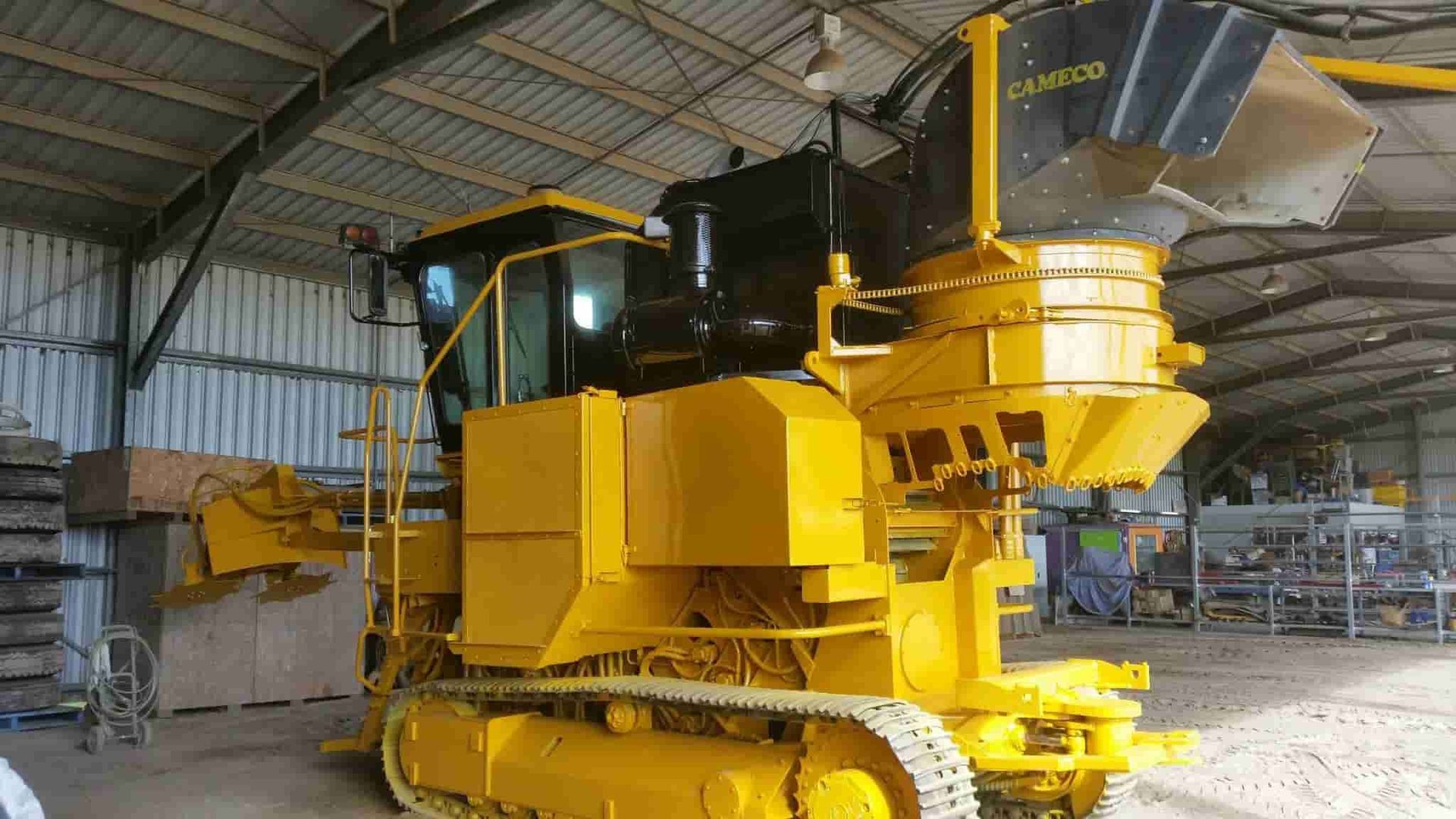 A Large Yellow Bulldozer is Parked in a Warehouse — North Queensland Hard Facing (NQHF) In Fredericksfield, QLD