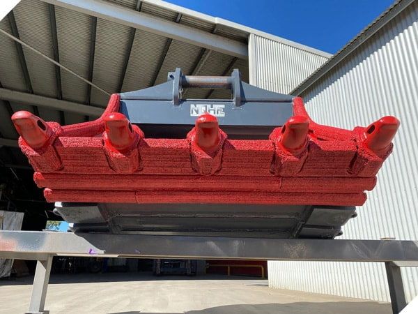 A Red and Black Object is Sitting on a Metal Stand — North Queensland Hard Facing (NQHF) In Fredericksfield, QLD