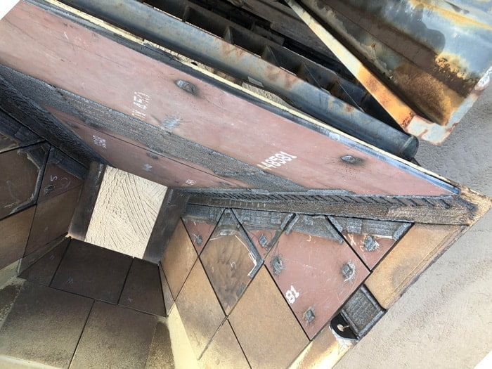 A Piece of Metal is Sitting on Top of a Wooden Table — North Queensland Hard Facing (NQHF) In Fredericksfield, QLD