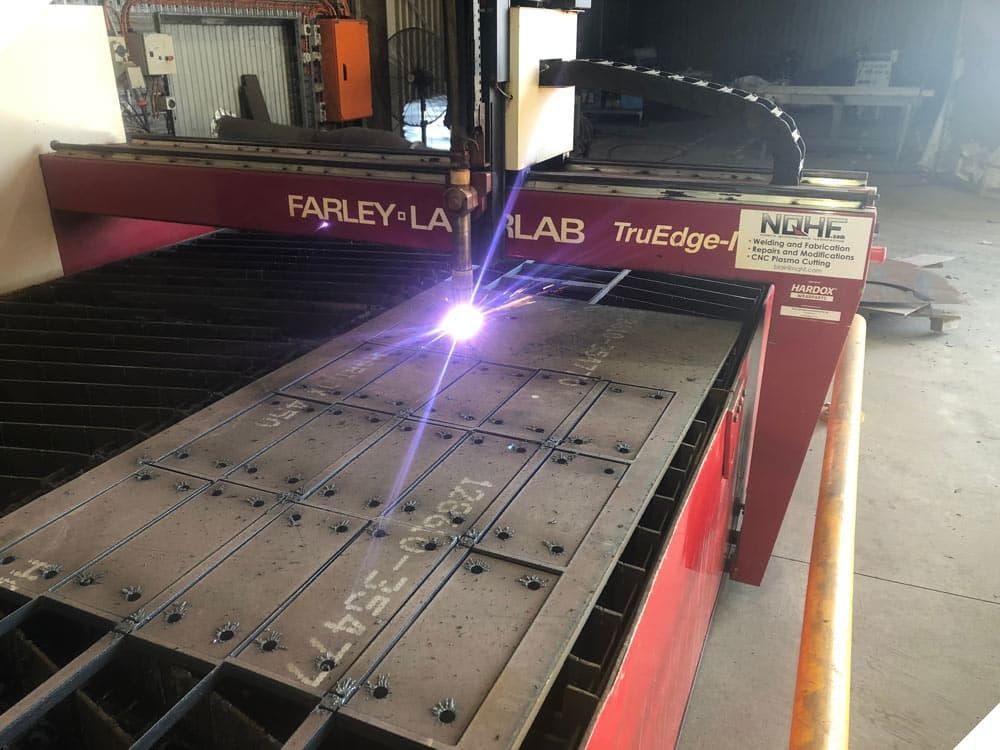 A Machine is Cutting a Piece of Metal in a Factory — North Queensland Hard Facing (NQHF) In Fredericksfield, QLD