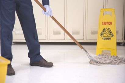 A Janitor Mopping The Floor With Caution Sign - Dover, OH - Rosmary's Cleaning Service