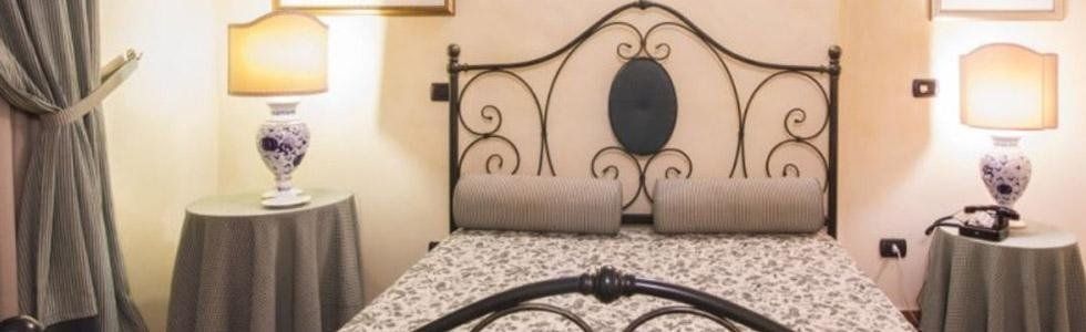 Camera da letto di matrimonio con letto di ottone, lampade di porcellana e comodini rotondi