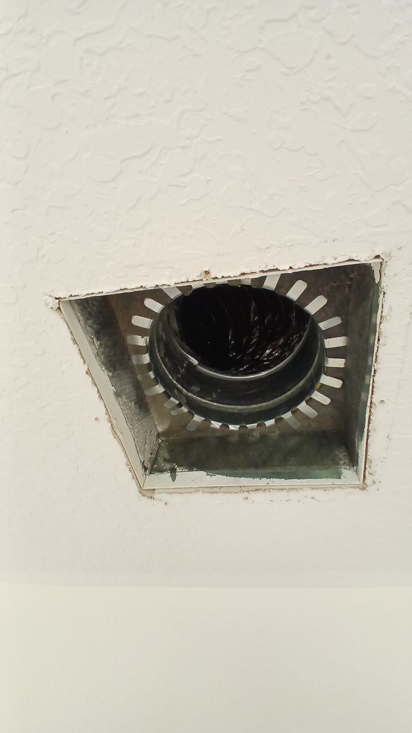 A square recessed ceiling light housing with a circular black interior opening set into a white plaster ceiling.