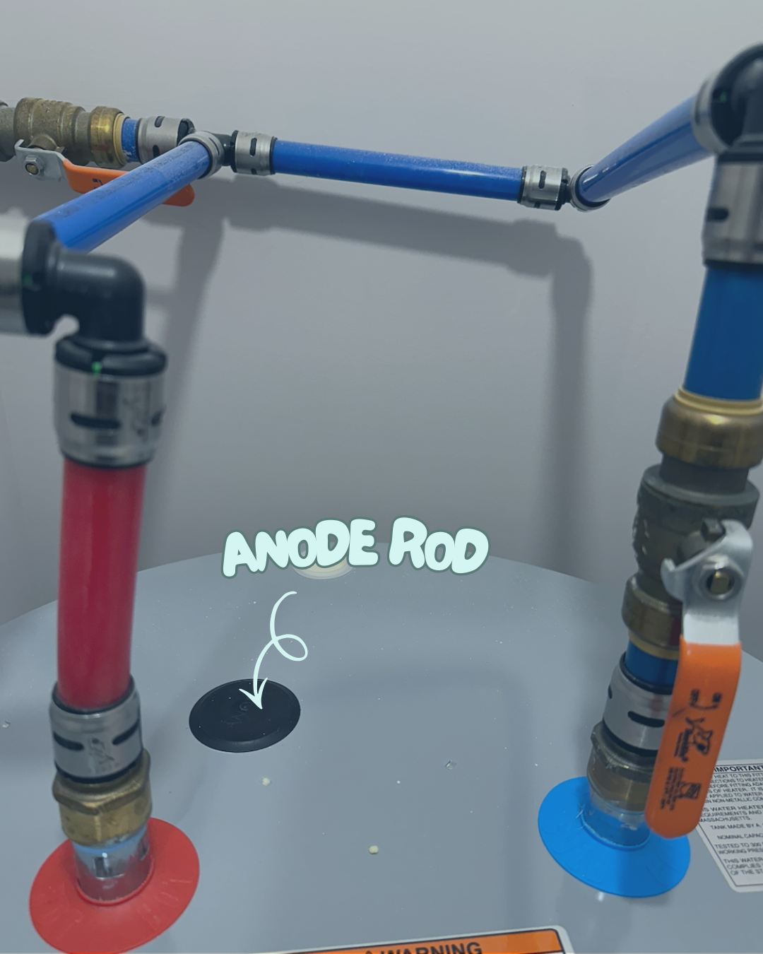 Close-up of top of electric water heater with anode rod labeled