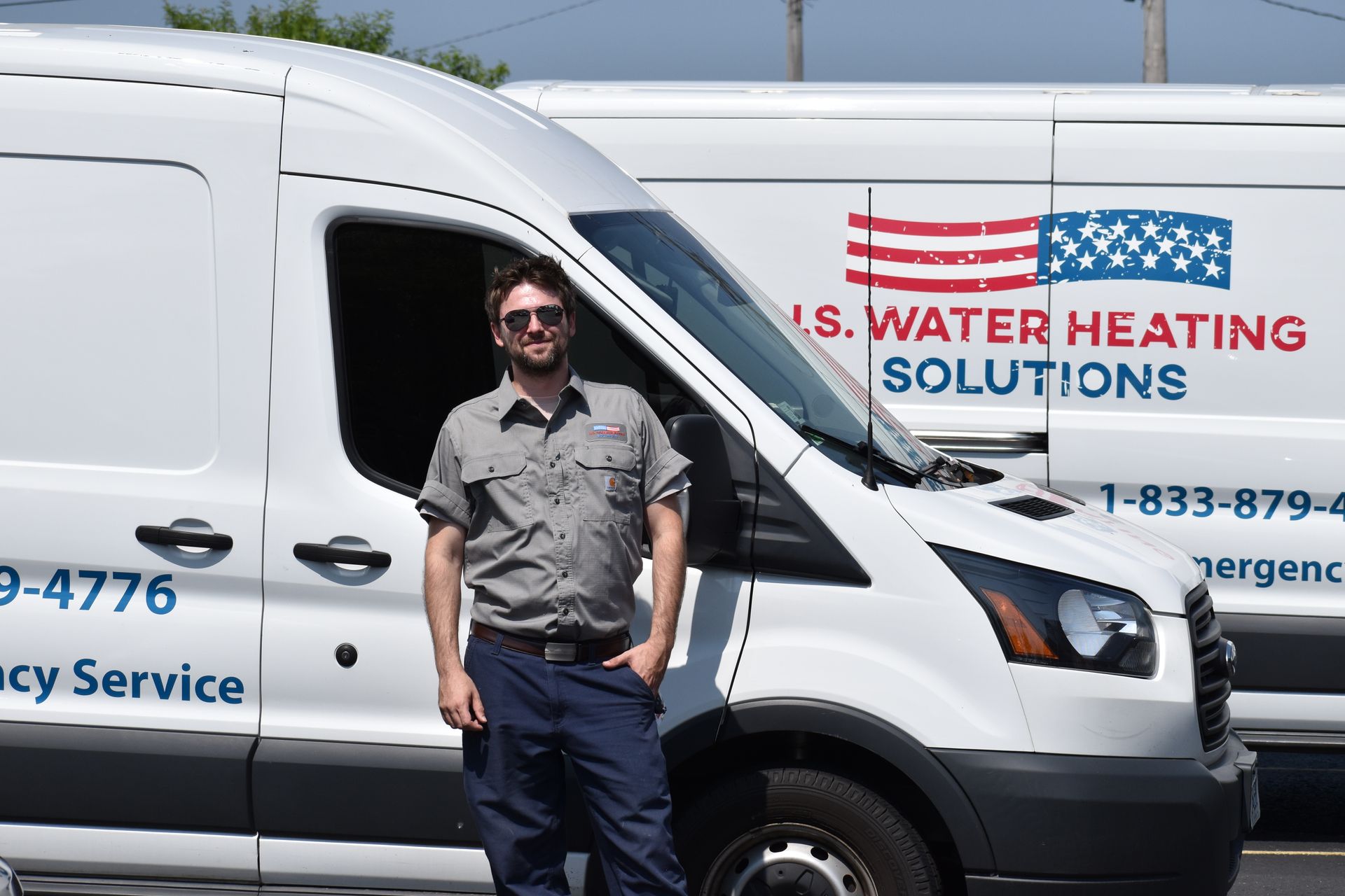 water heater repair technician standing next to his truck