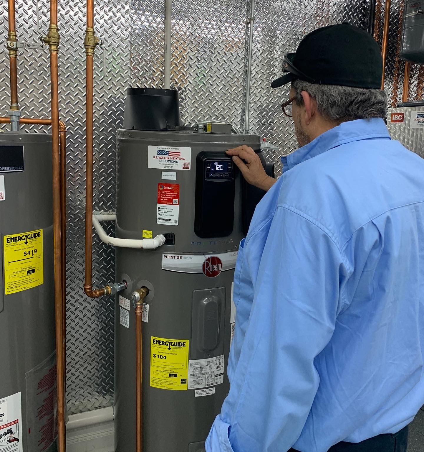 U.S. Water Heating Solutions technician diagnosing and repairing issue with hybrid heat pump water heater