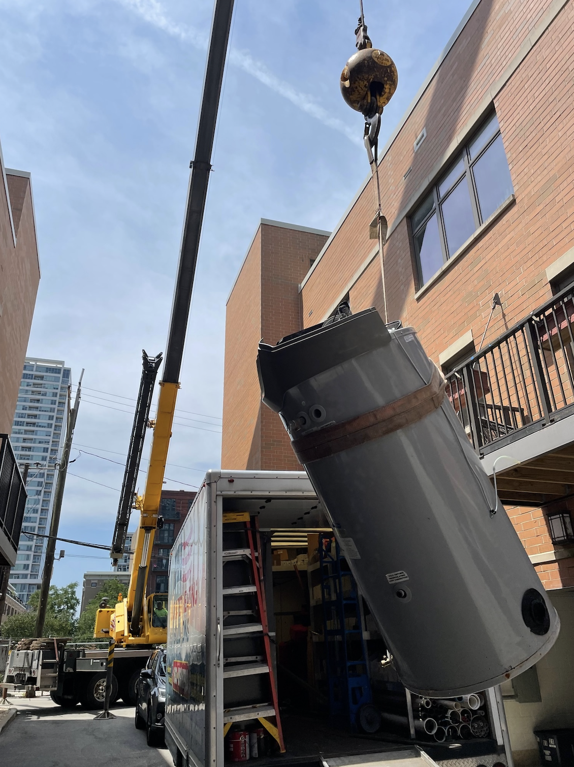 water heater being air craned from apartment building