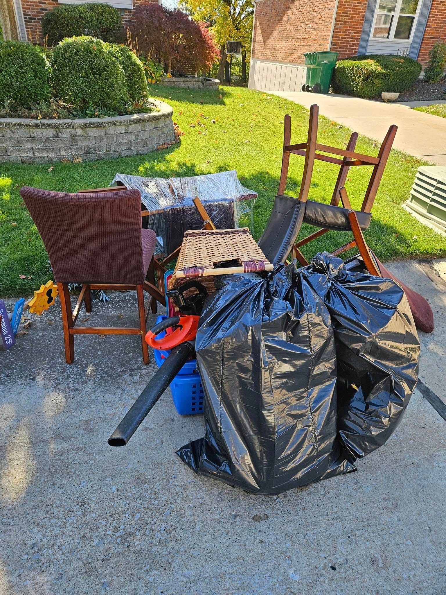 A pile of trash is sitting on the sidewalk in front of a house.