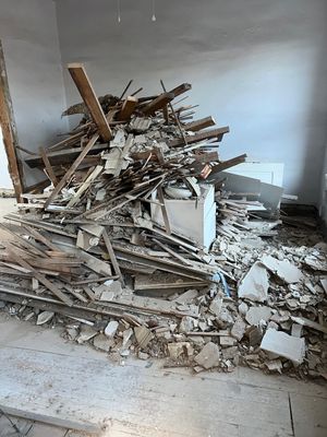 A bathroom under construction with a toilet and a pile of trash.