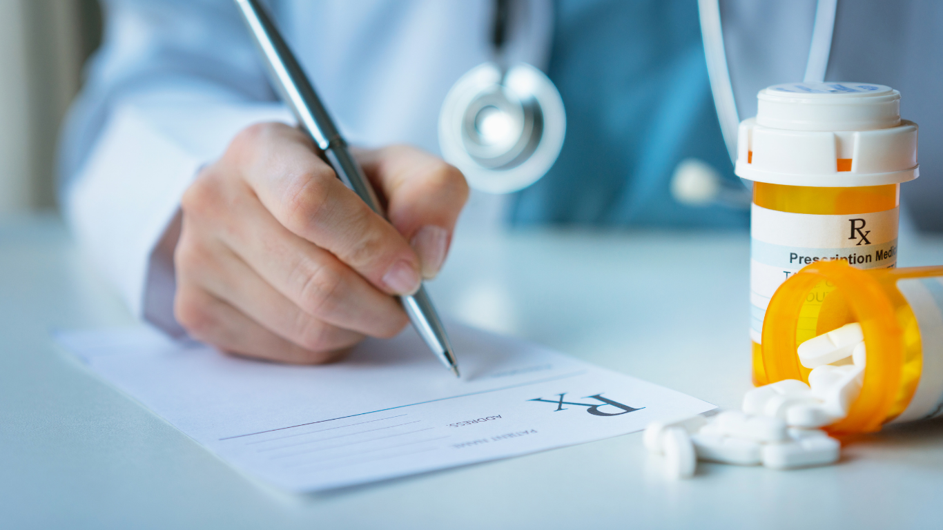 Hands holding several blister packs of pills.