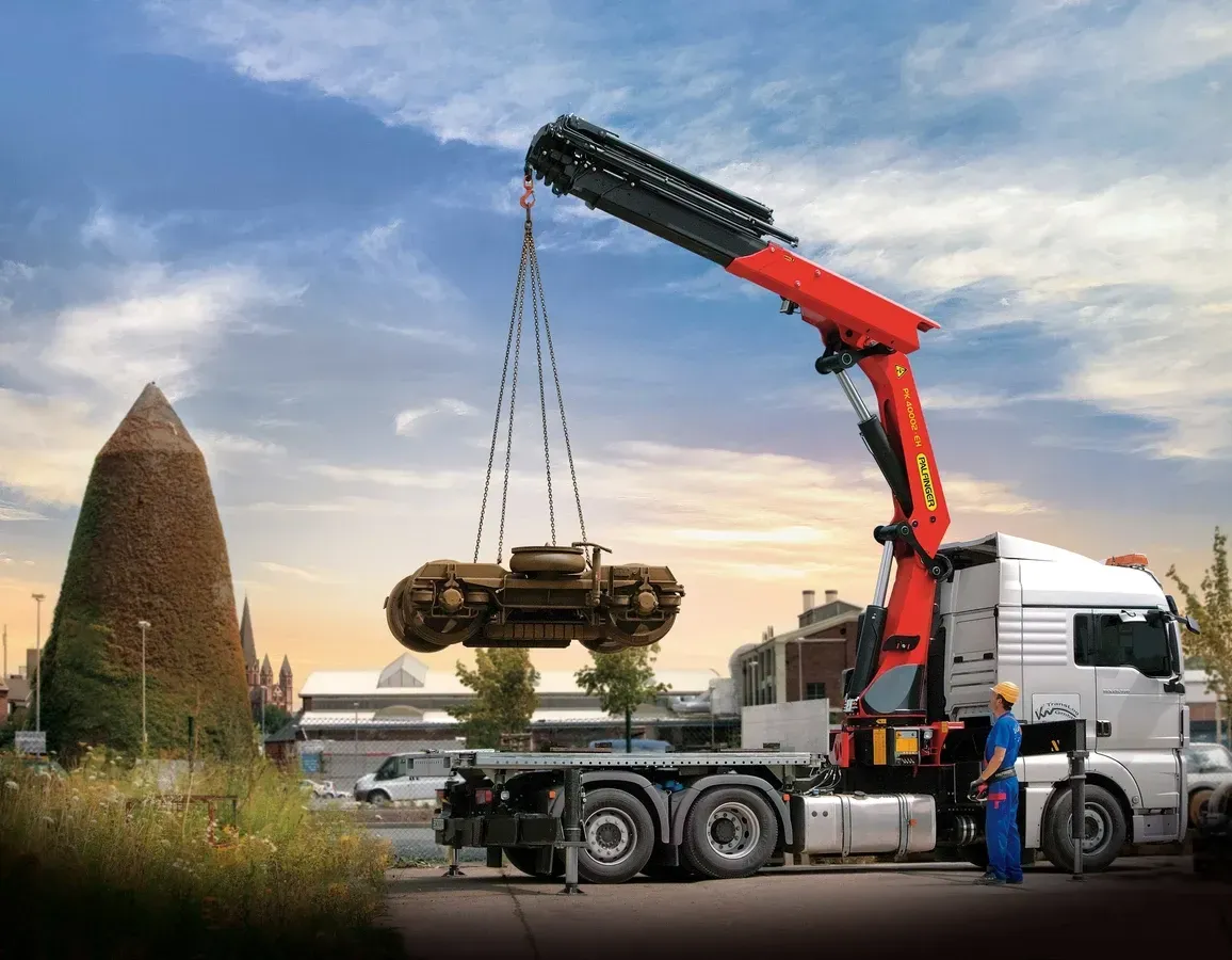 Un camión con una grúa acoplada está levantando un coche.