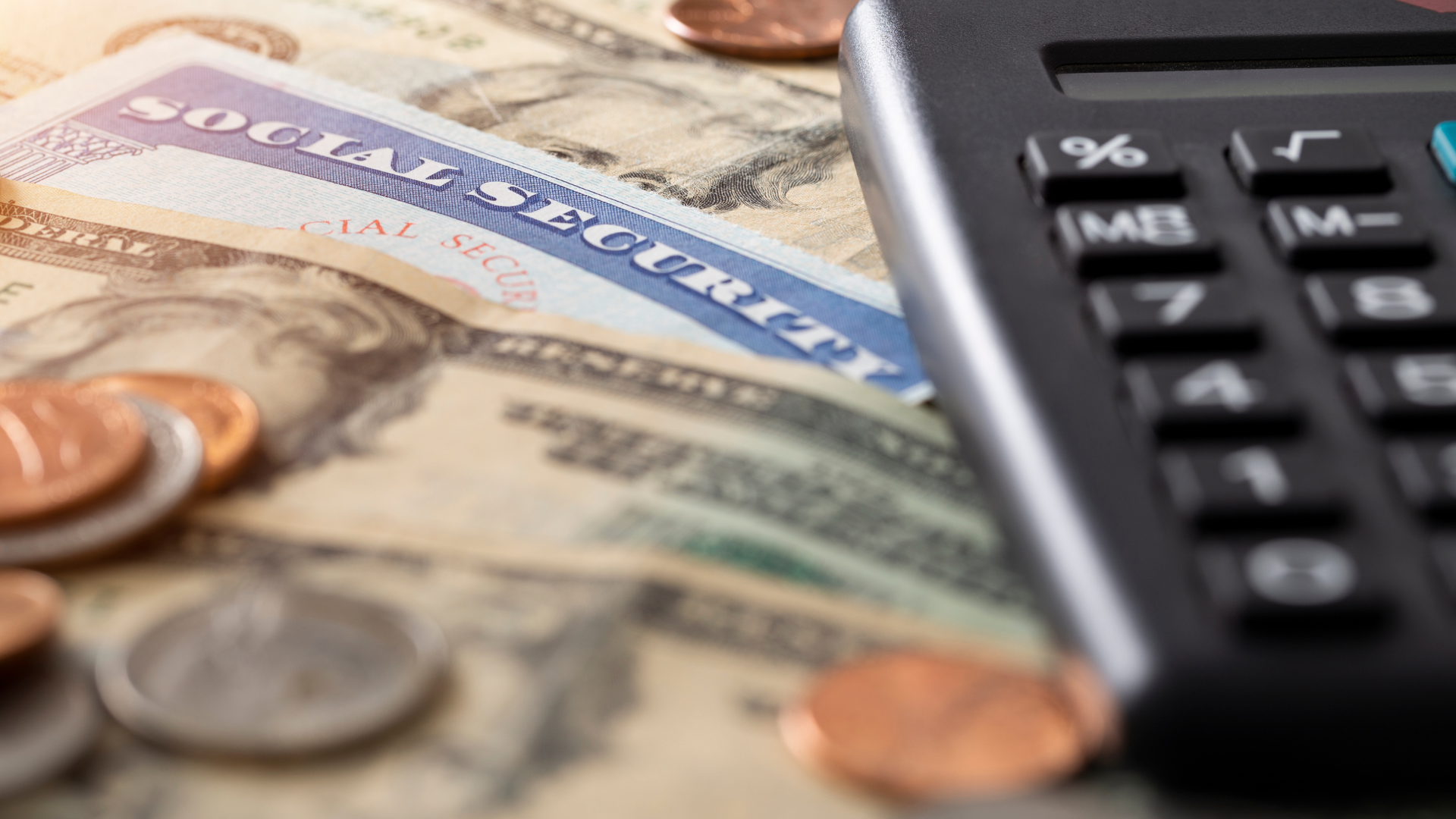 A calculator is sitting on top of a pile of money and coins.