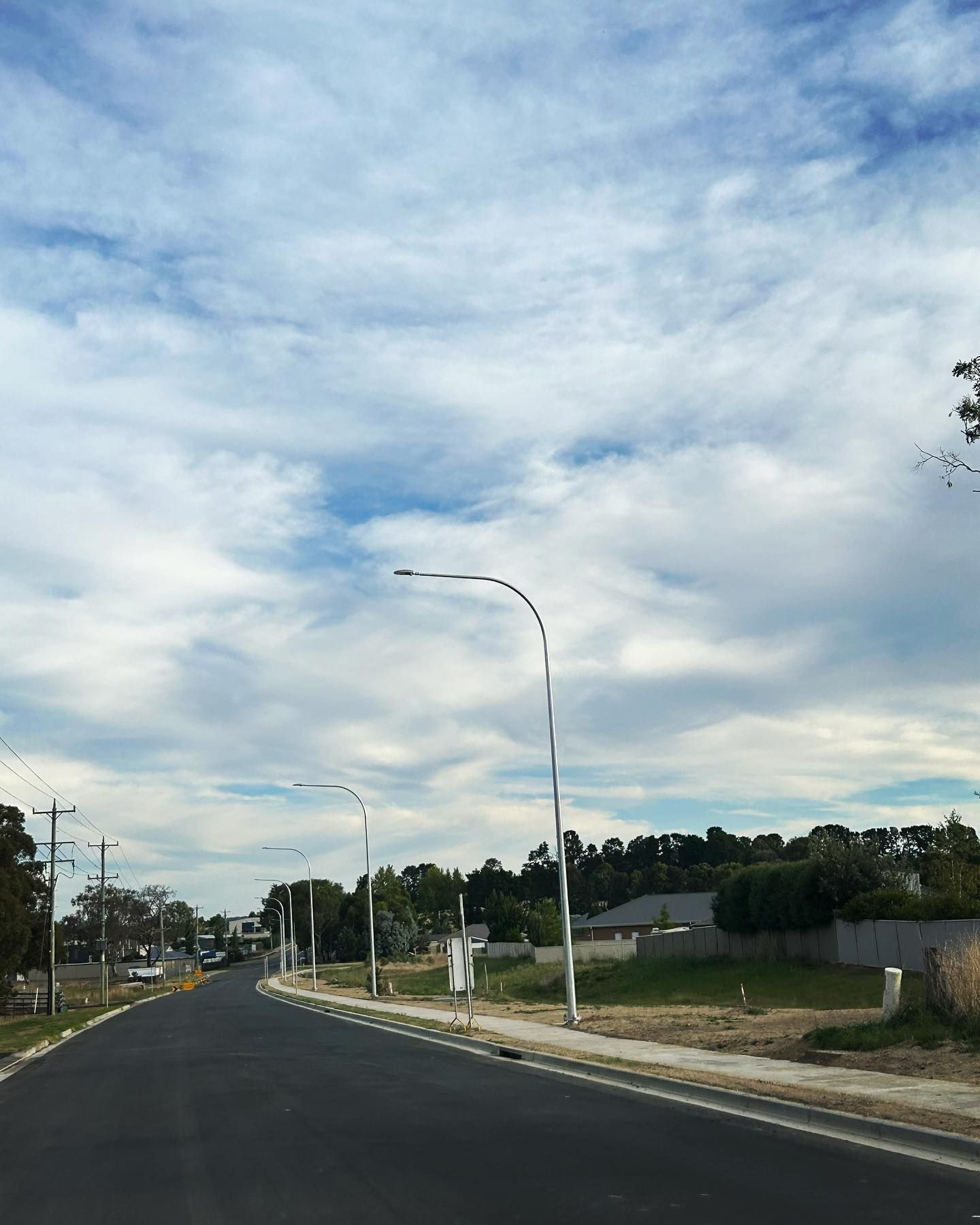 Empty Road With Streetlights Under a Cloudy Blue Sky — Central West Power Construction in Orange, NSW