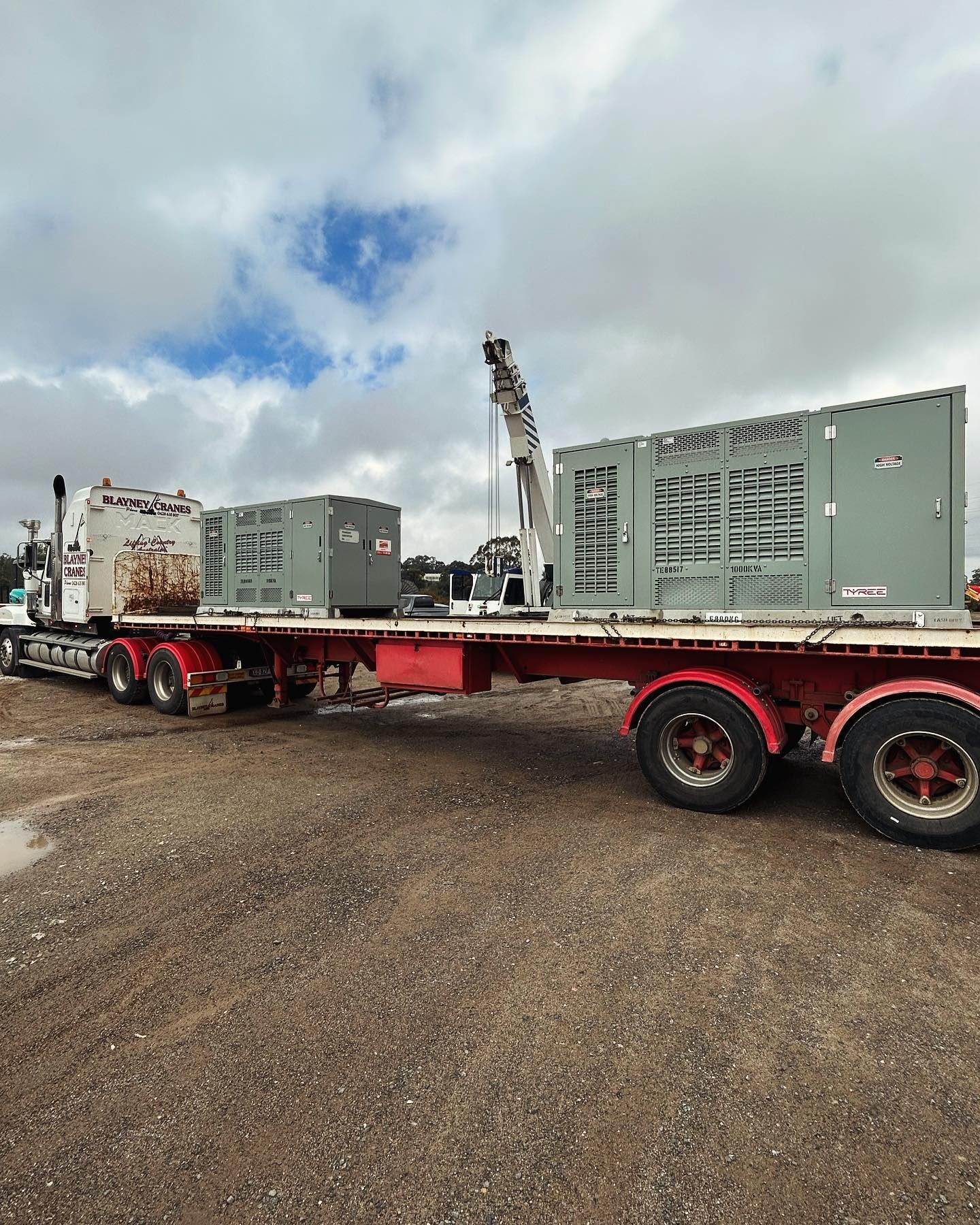 Semi-truck Flatbed Transporting Two Large Gray Industrial Boxes — Central West Power Construction in Orange, NSW