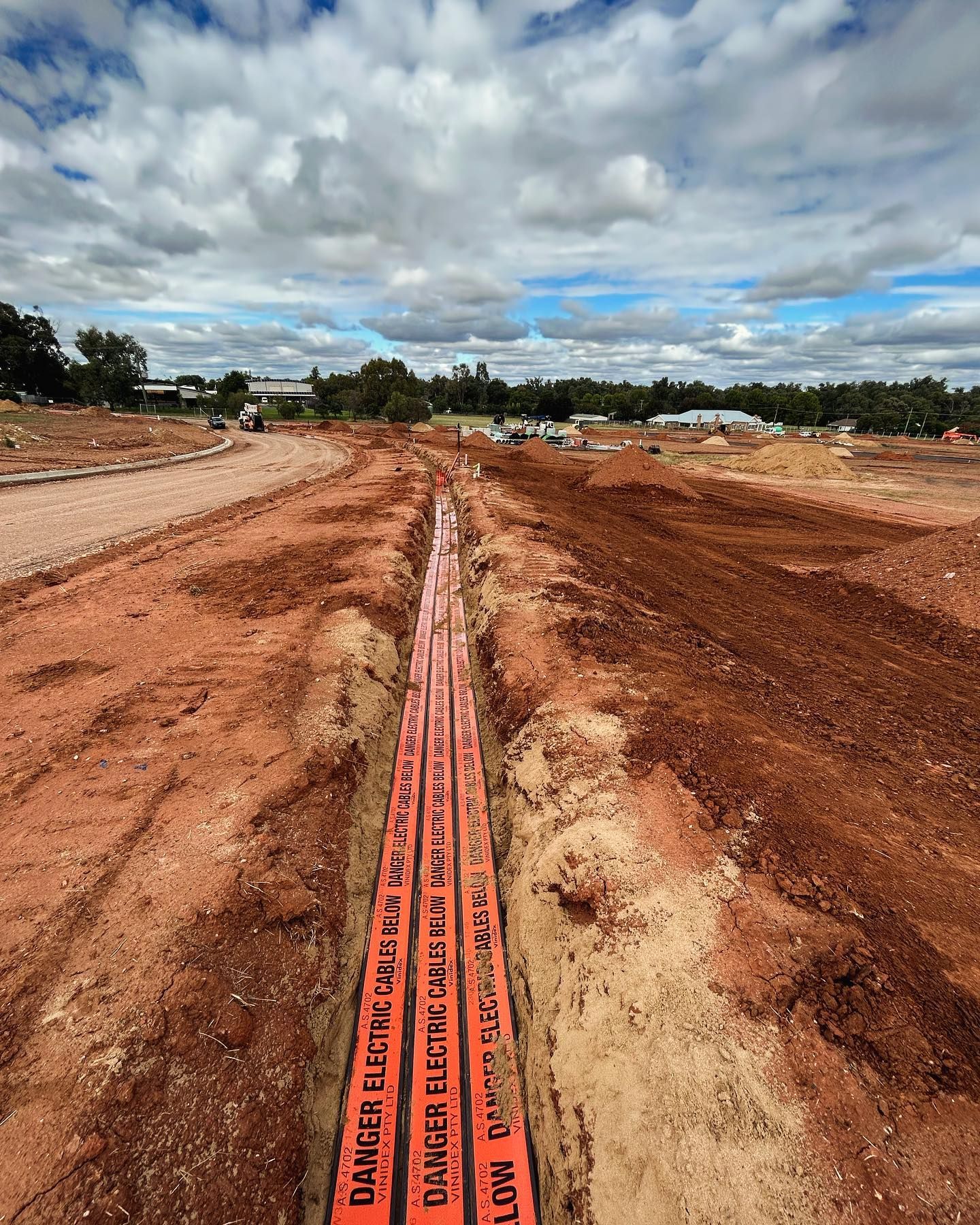 Orange Electrical Conduit Buried in a Trench, Marked With Danger  Cable — Central West Power Construction in Orange, NSW