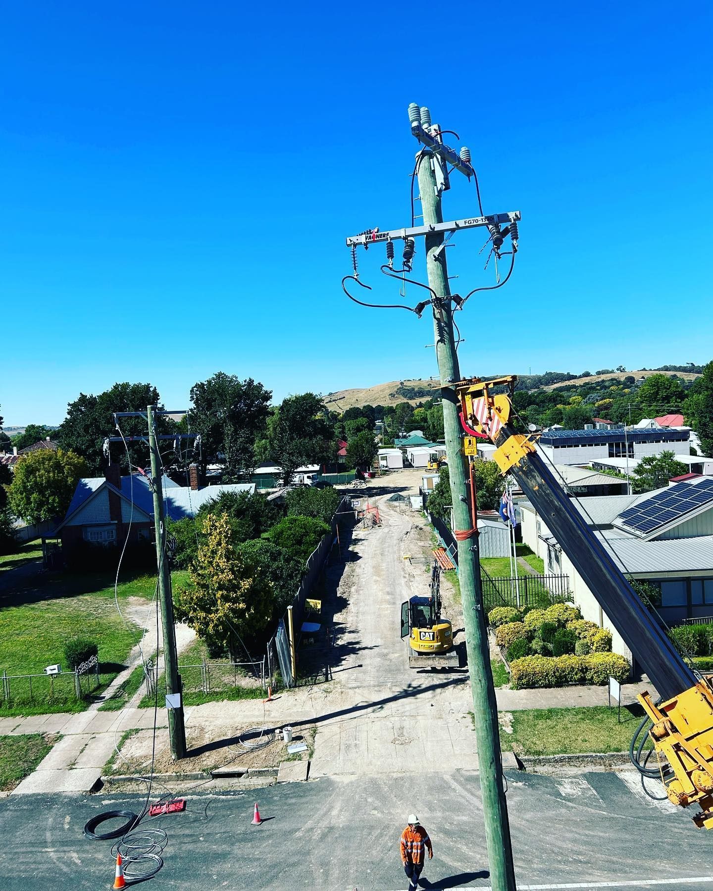 Electrician Working on a Utility Pole on a Sunny Street — Central West Power Construction in Orange, NSW
