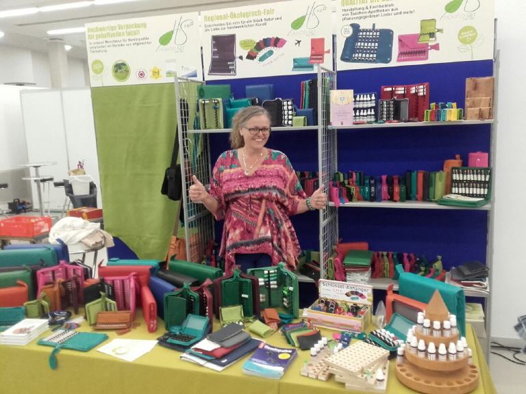 Eine Frau steht vor einem Tisch voller bunter Gegenstände