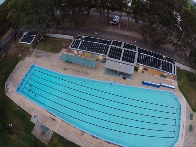 A swimming pool with solar panels on the roof