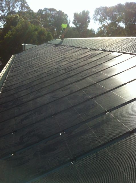A roof with a lot of solar black panels on it