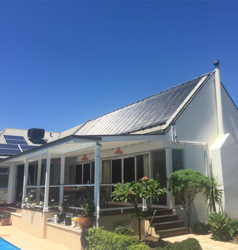 A white house with solar panels on the roof