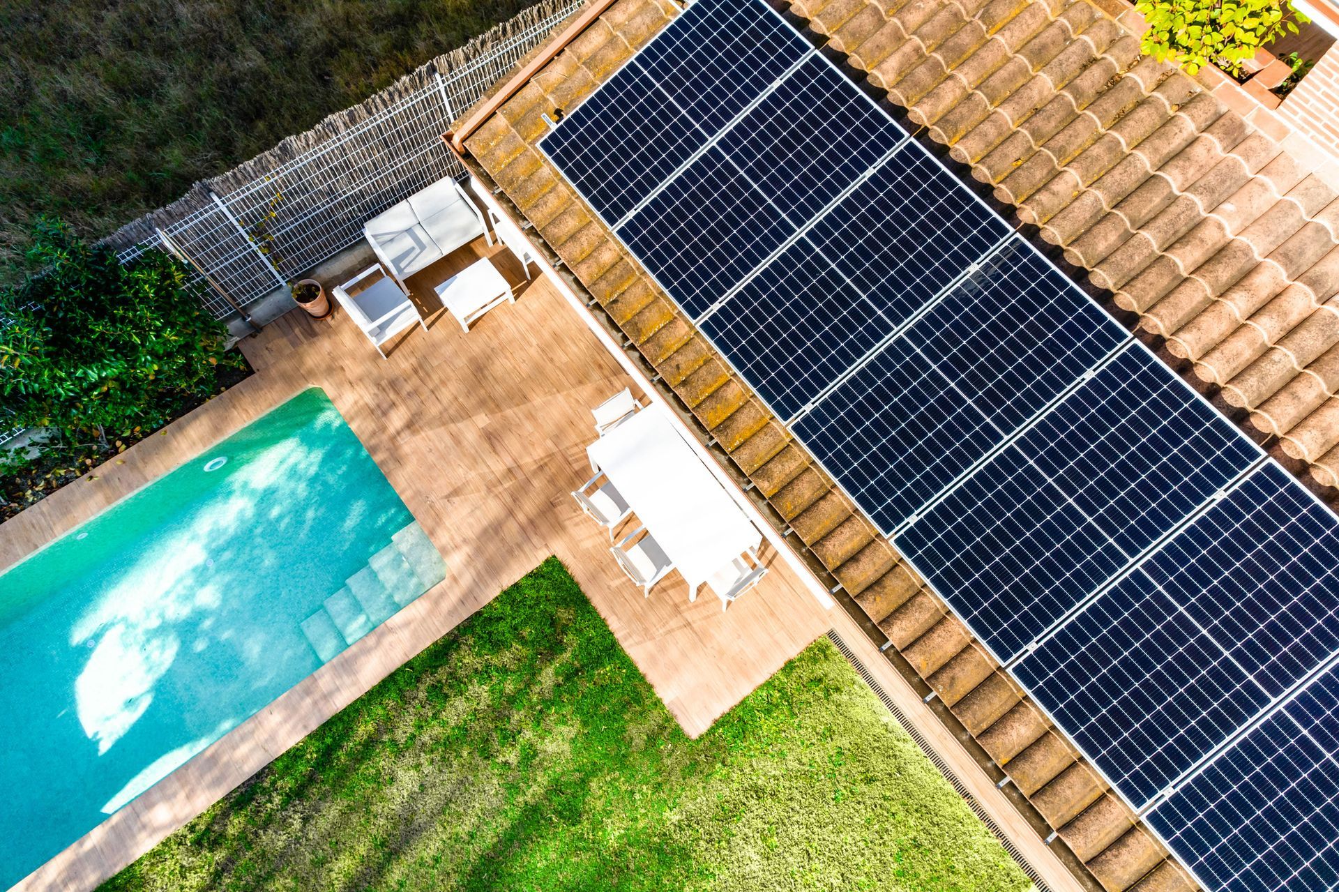 Aerial overhead view of a house with a pool and solar panels.