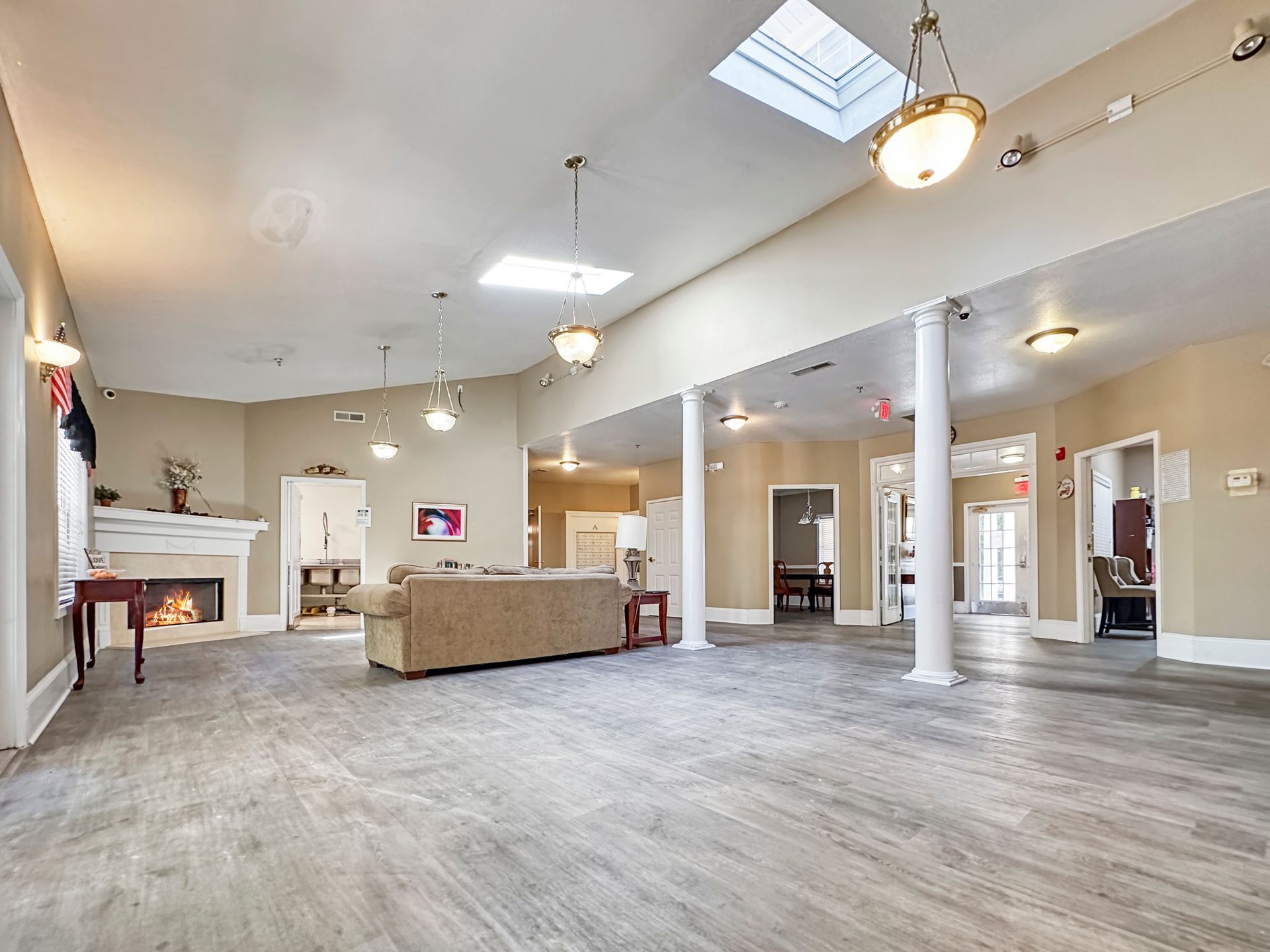 A large living room with a couch , fireplace , and skylight.