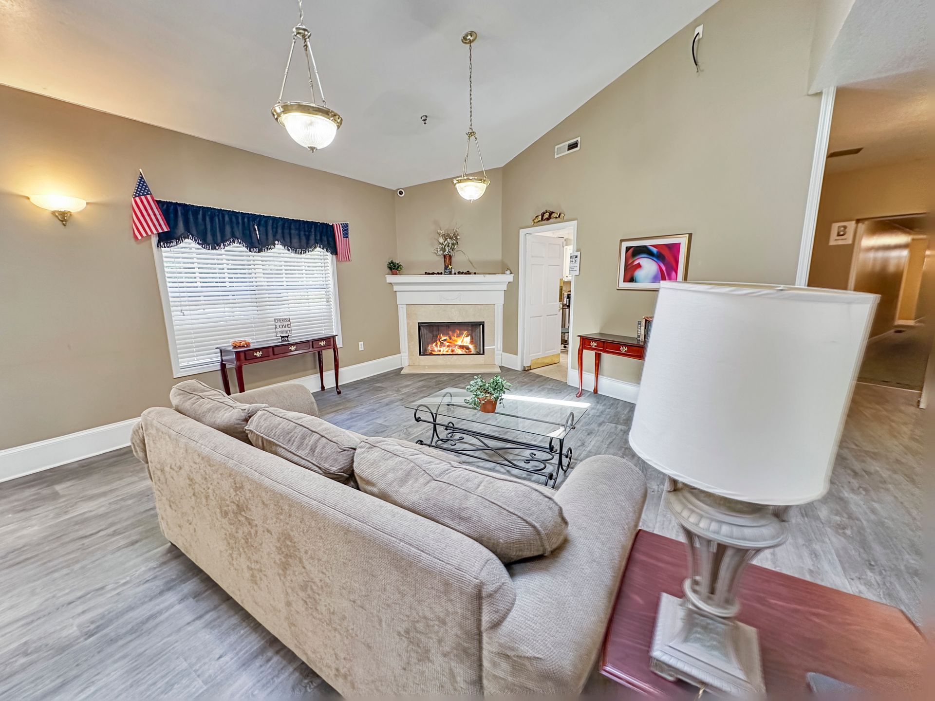 A living room with a couch , fireplace and lamp.