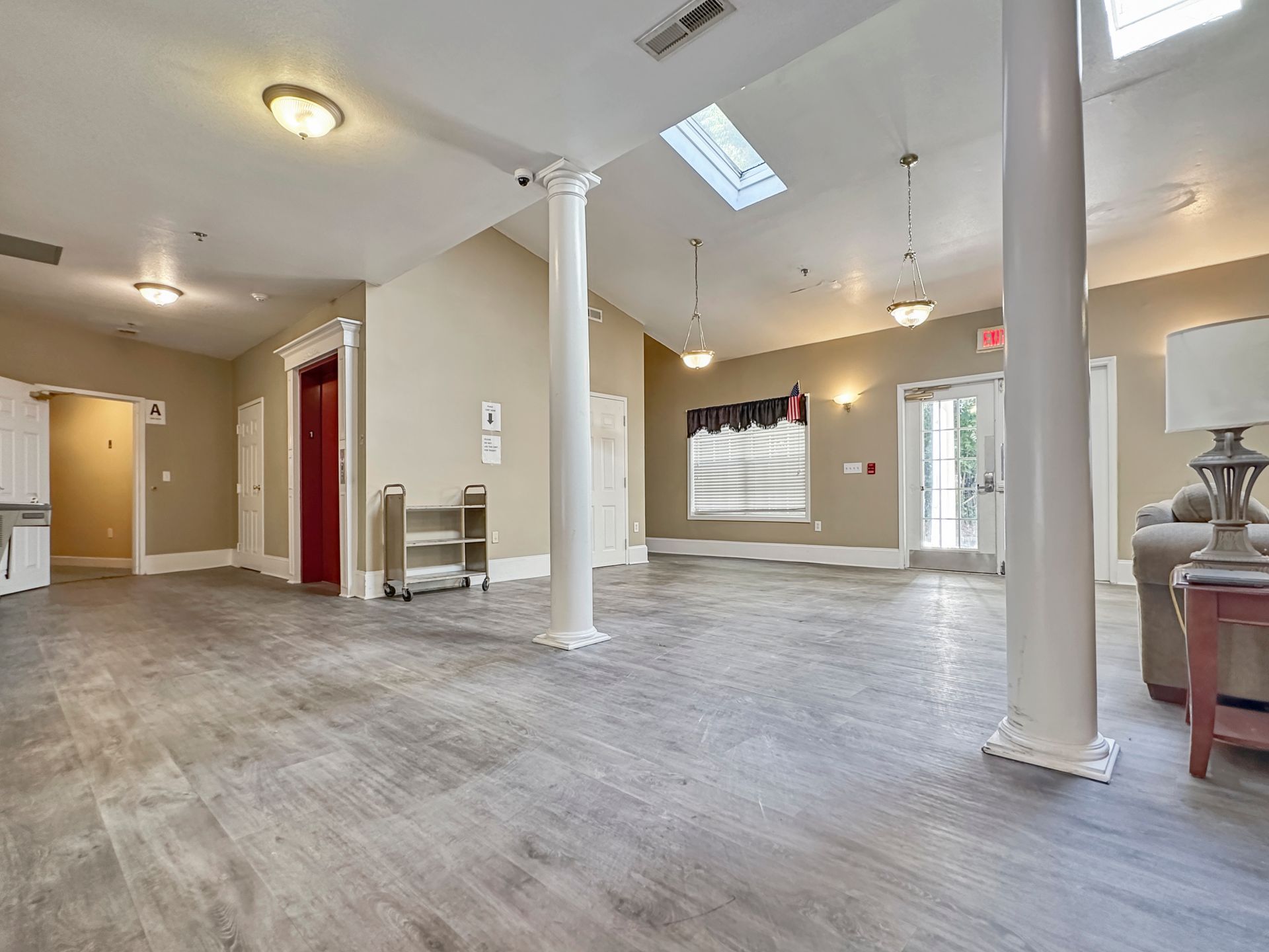 A large room with hardwood floors and a skylight in the ceiling.