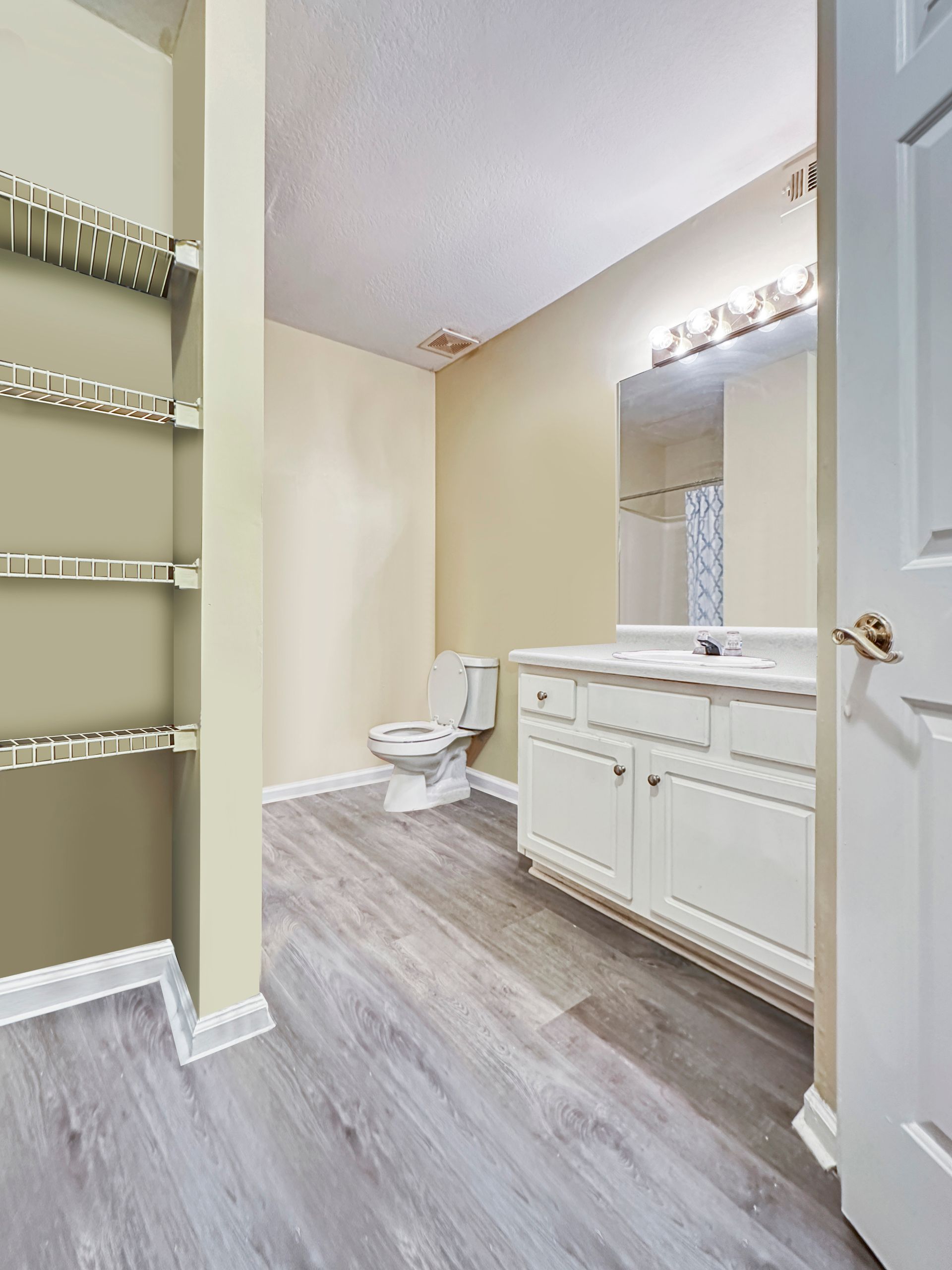 A bathroom with a toilet , sink and mirror