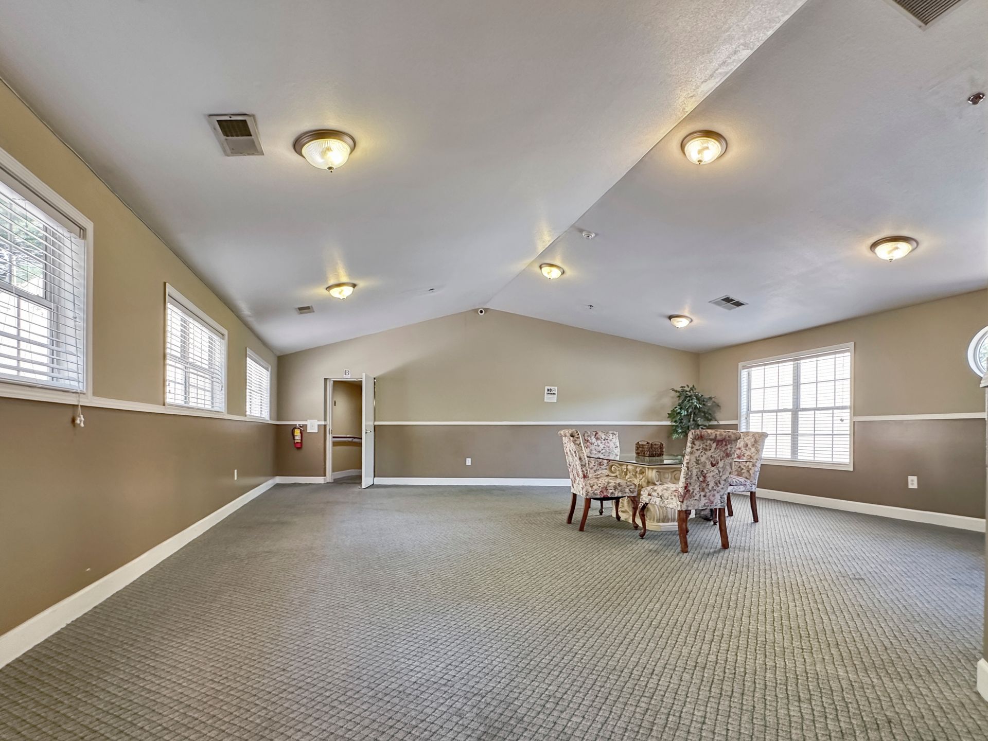 A large empty room with a table and chairs in it.