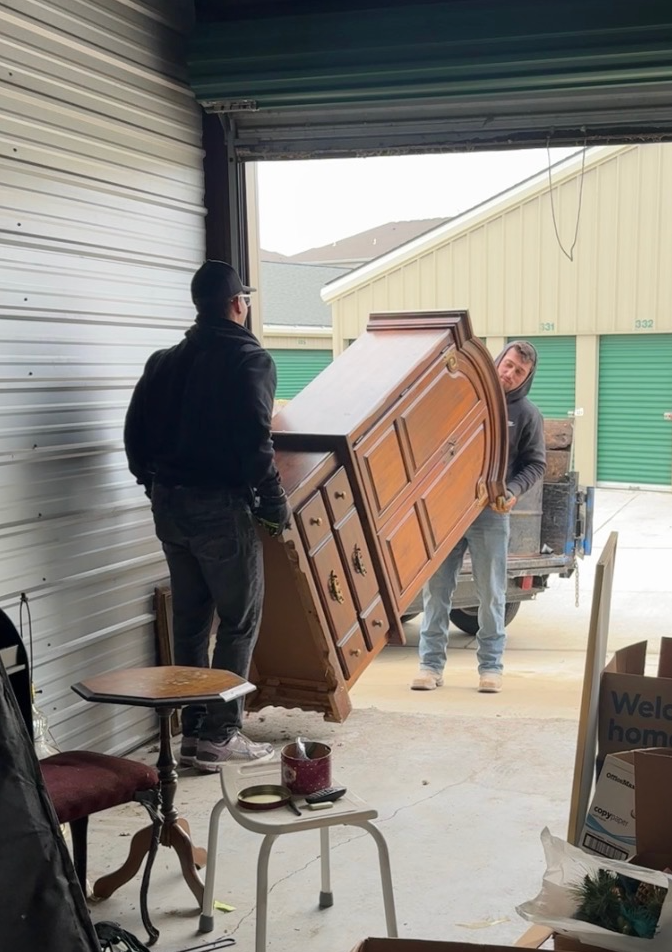 A pile of discarded furniture, trash bags, and household items left on a suburban curbside for collection.