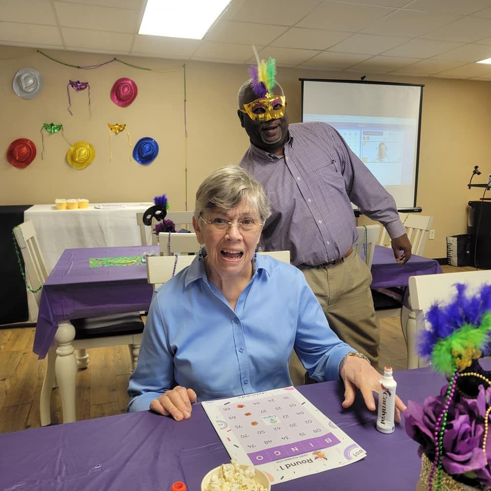 A man and a woman are sitting at a table with a purple table cloth