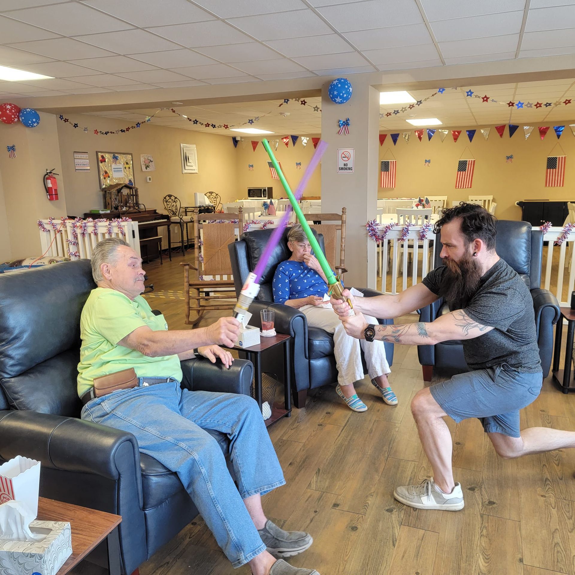 A group of people are playing with lightsabers in a living room.
