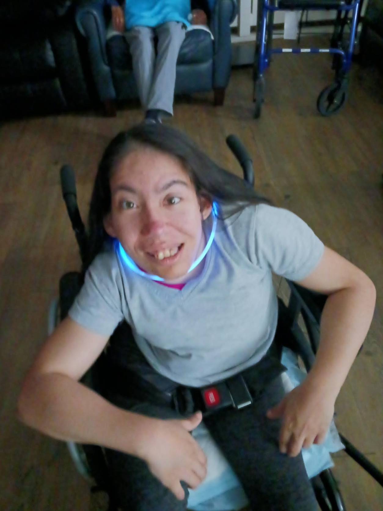A woman in a wheelchair with a light on her neck