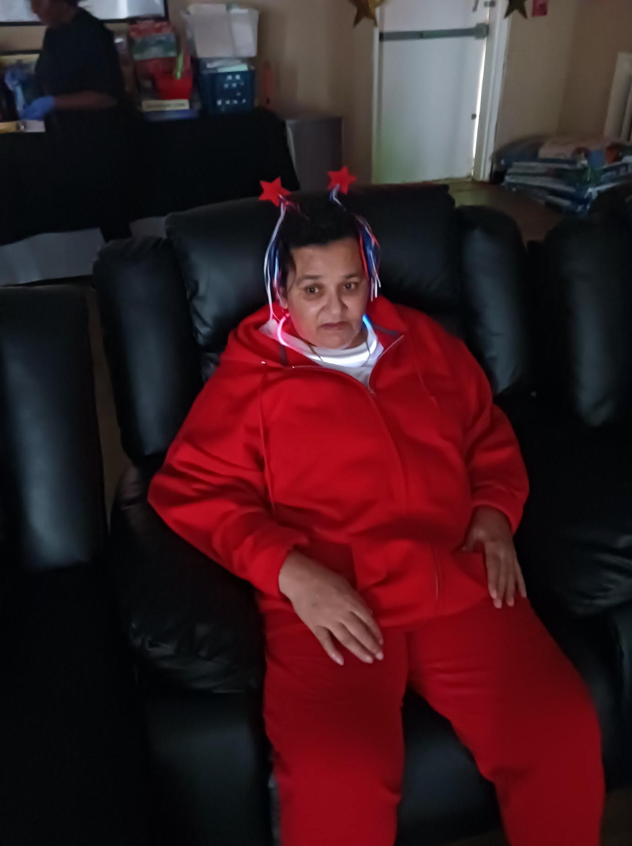 A woman in a red jacket is sitting in a black chair