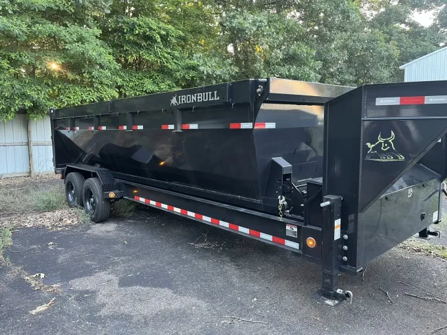 Black dump trailer parked outside.