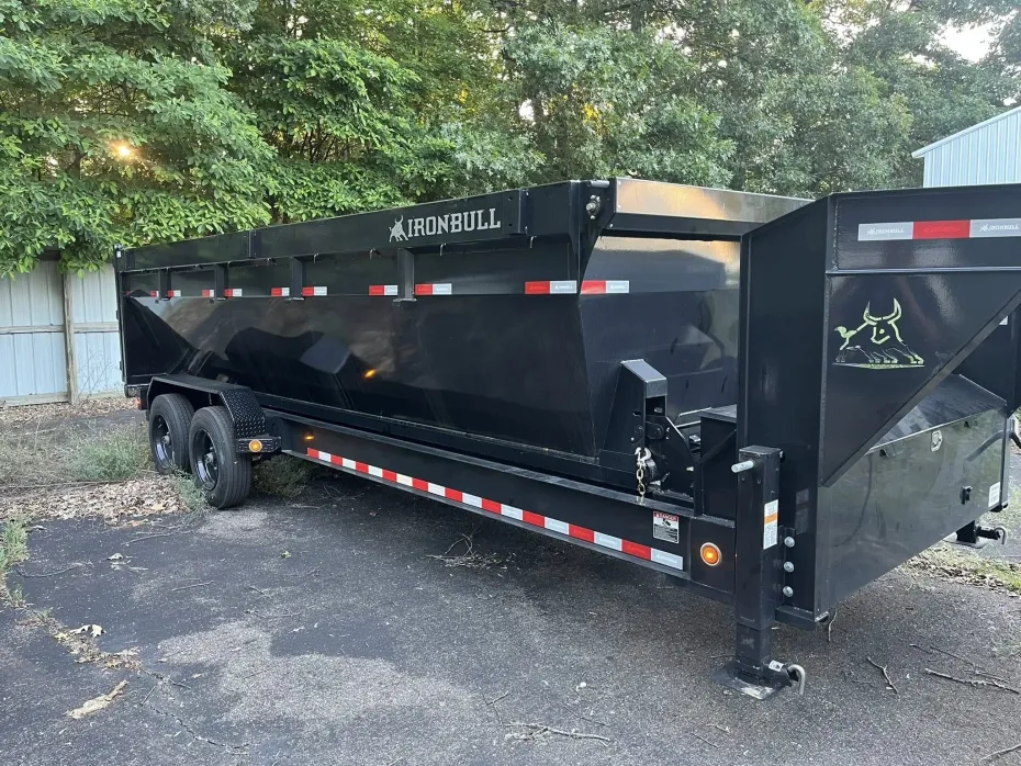 Black dump trailer parked outside.