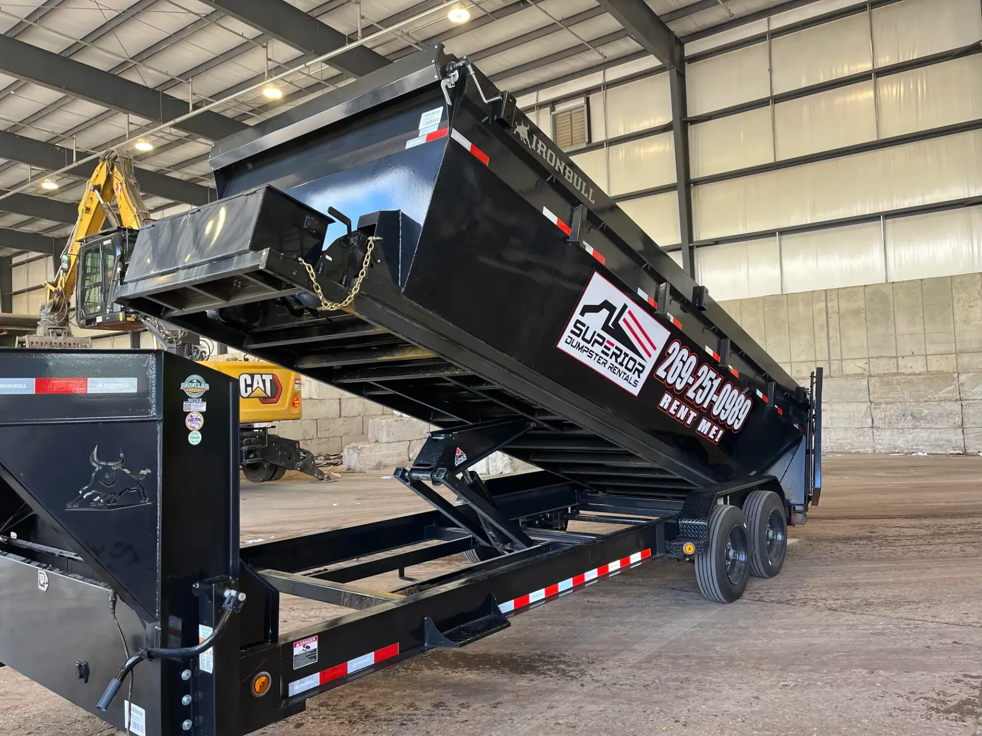 Black dump trailer parked outside.