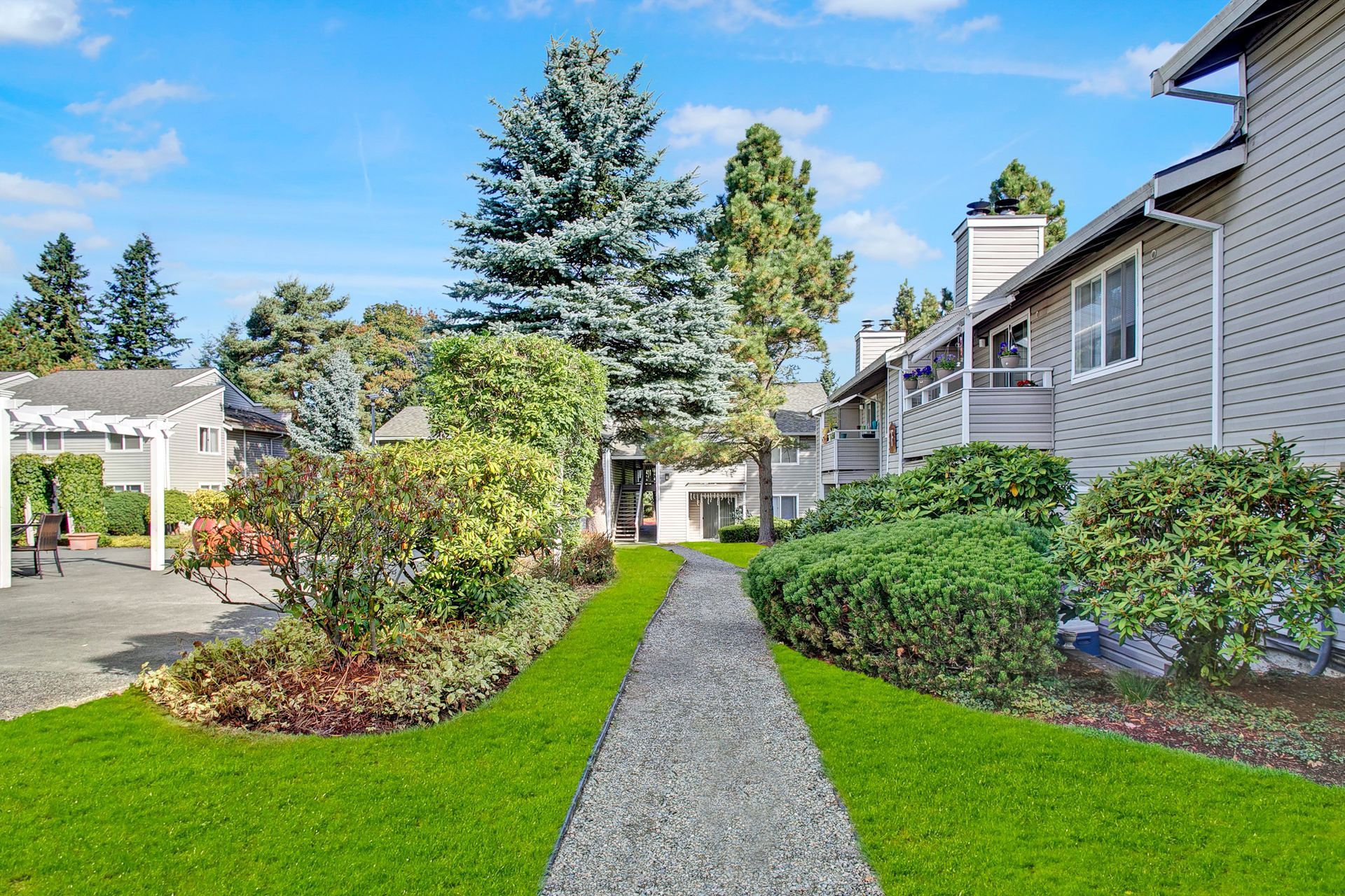 A path leading to a house with a lush green lawn.