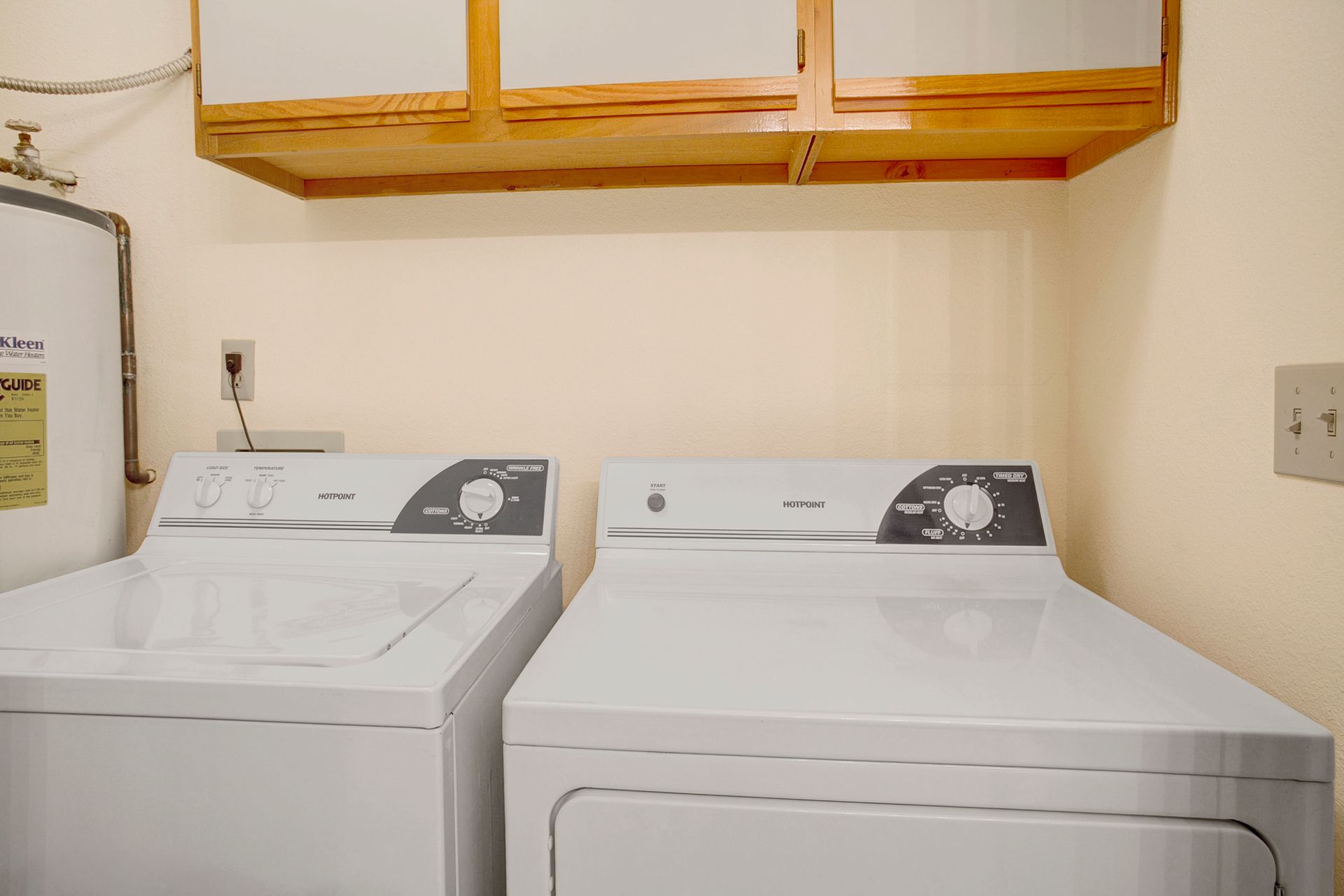 A laundry room with a washer and dryer and a water heater.