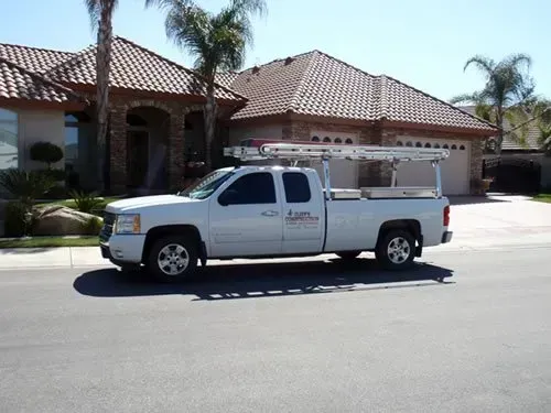 A white truck is parked in front of a house
