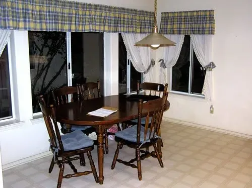 A dining room with a table and chairs and a window