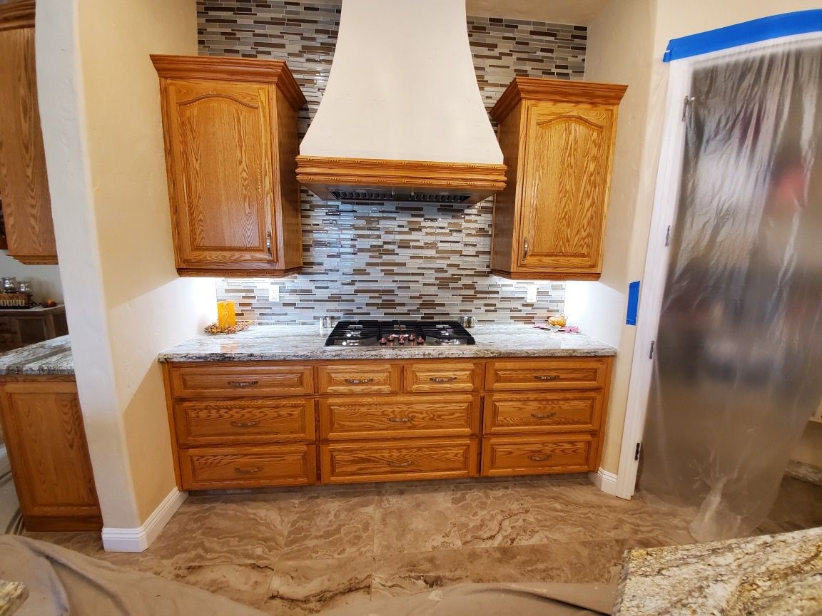 A kitchen with wooden cabinets and a stove top oven.