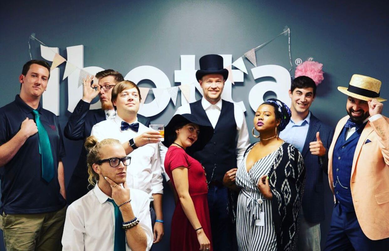 A group of people are posing for a picture in front of a sign.