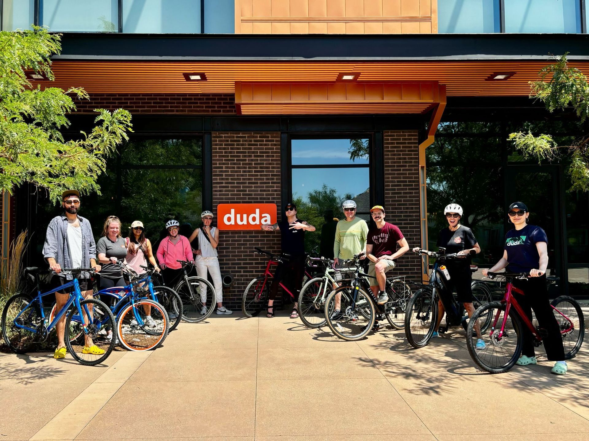 A group of people standing in front of a building with bicycles.