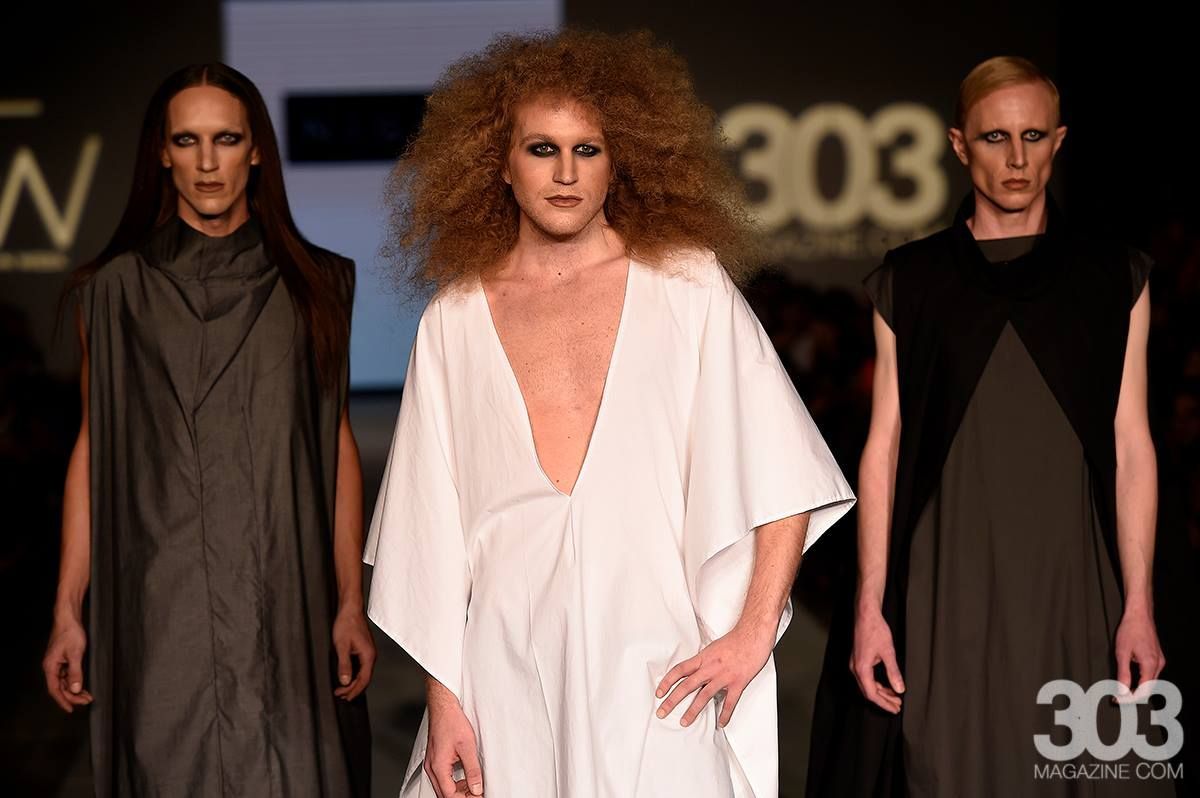 Three models are walking down a runway for Denver Fashion Week.