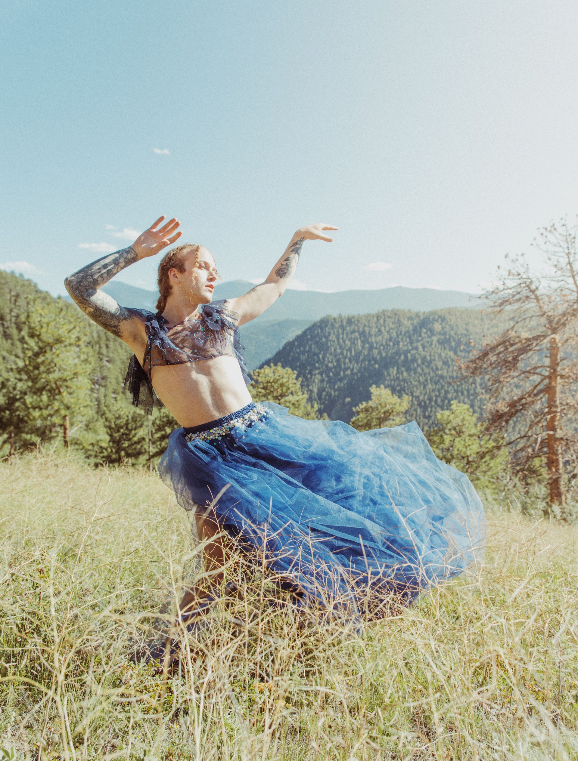 Scotty modeling outside in a tule blue dress for a photoshoot in the mountains 